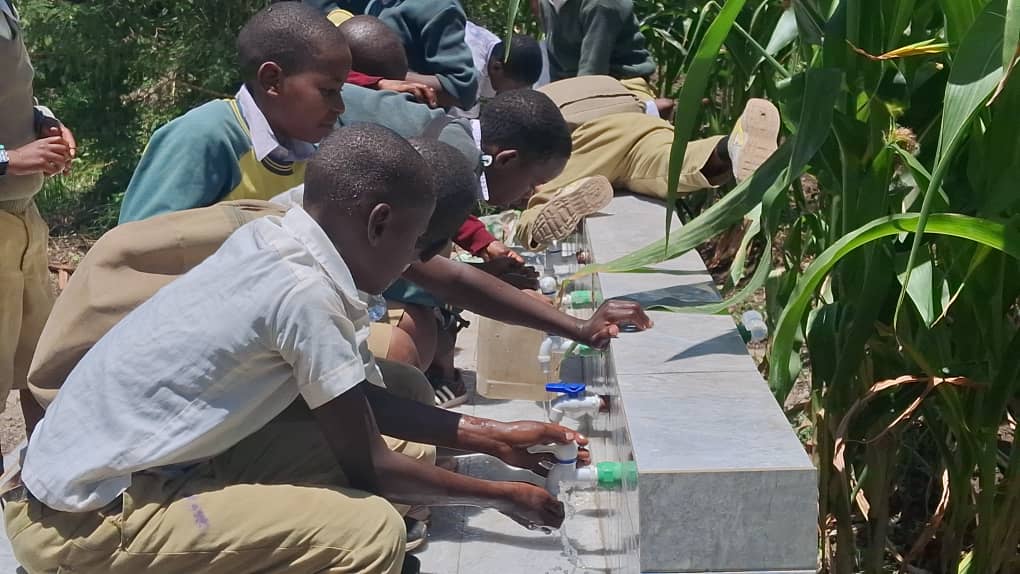 Community members celebrating clean water from new borehole in Tanzania
